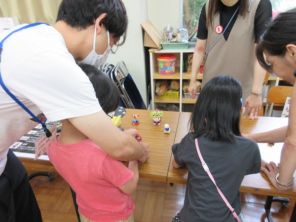 江戸時代の玩具「とんだりはねたり」を触る子どもたち