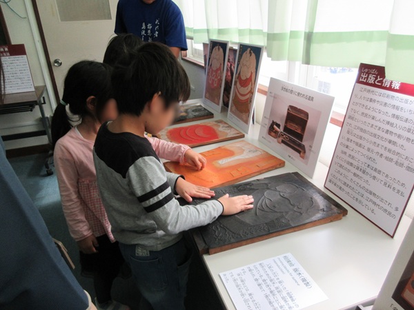 版木のレプリカを触る児童たち