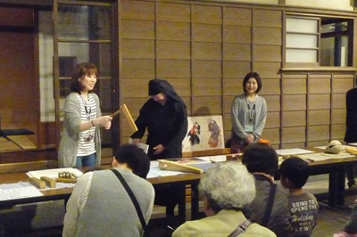 がり時計を持って説明するスタッフの画像