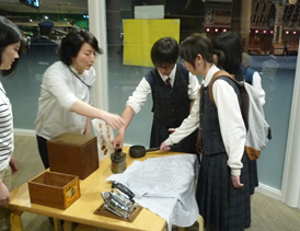 修学旅行生が学芸員から解説を受けている画像