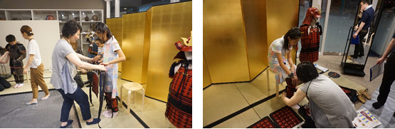 学芸員が試着を手伝う様子の画像